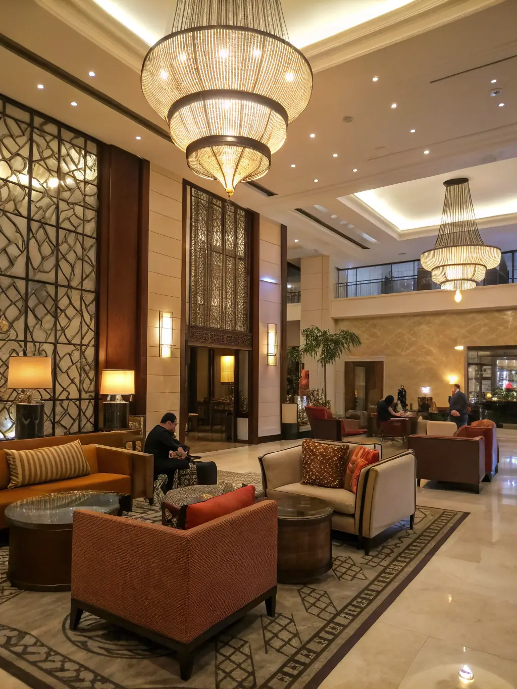 A luxurious hotel lobby undergoing renovation, with workers installing new flooring and lighting fixtures, while guests are still present in a designated area, showcasing minimal disruption.